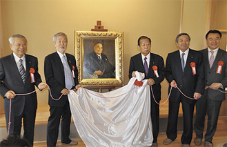肖像画の除幕を行う中崎町長（中央左）と二階幹事長（中央）ら