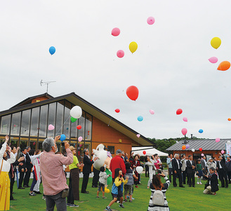 オープンを祝って風船を飛ばす式典の参加者