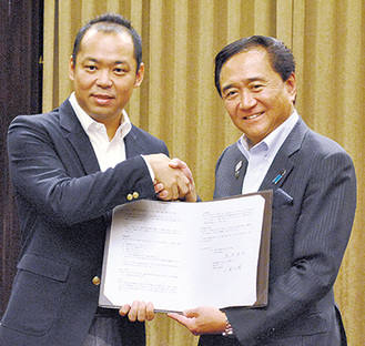握手を交わす小泉社長（左）と黒岩知事