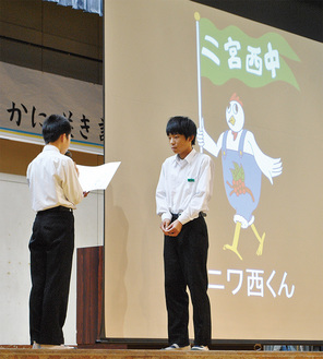 生徒会長の中谷さん（左）から表彰を受ける、マスコットキャラクター考案者の荒木さん