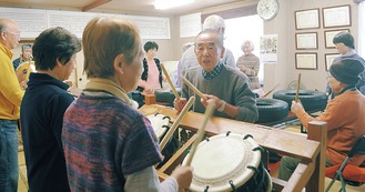 小泉さん（中央）の指導で小太鼓を叩く参加者