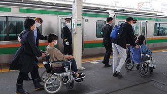 平塚駅で車椅子の移動体験をする会員と池田議員