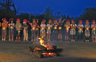 キャンプファイアを囲み、歌を発表する園児たち