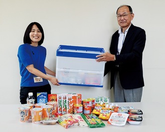 センター職員から食品類を受け取る関野会長(右）