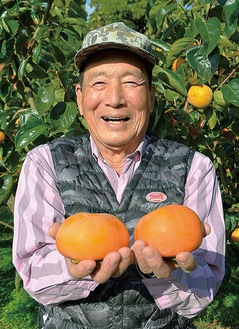 大玉柿を手にする鈴木農園の鈴木さん