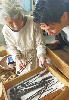 道具を見る中野さんと川村さん（提供写真）