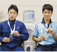 金メダルを持つ柏木さん（左）と銅メダルを持つ田代さん（右）。柏木さんはアクアクララの製造を、田代さんは配達を担当している