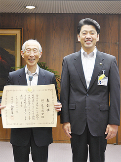 市長室で行われた伝達式。表彰状を手にする山田会長（左）