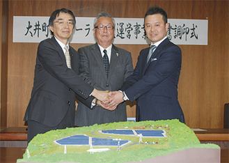 握手を交わす（右から）古川社長、間宮町長、黒川副知事