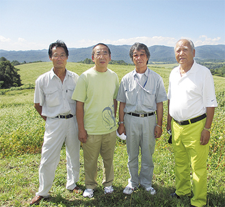 北海道のそば畑で久津間会長（右）と契約農家の高橋庄作さん（左）、目黒時夫さん（会長隣）