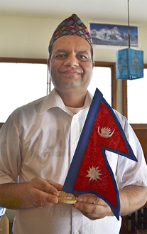ネパールの国旗を手にするサプコタさん