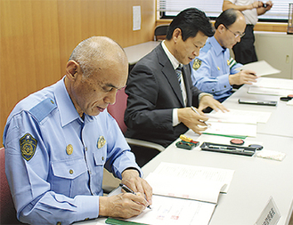 協定書にサインをする（右から）山口松田署長、曽我支部長、徳正小田原署長