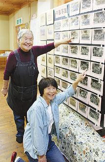 毎年の卒園写真の記念展示を前に、自身が映る写真を指差す門松萬喜子さん（左）と勝俣ゆりさん