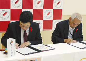 調印書に署名する栗田さん（左）と木村さん