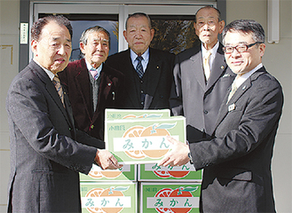 秋山会長（左）から桑田院長（右）にみかん１００kgが渡された