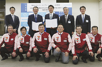 協定書を持つ加藤市長（後列中央）と（株）セブン−イレブン・ジャパンの百瀬神奈川ゾーンマネジャー（市長左）。前列は市内のセブン−イレブンオーナー