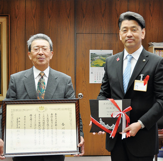 加藤市長から賞状と楯を授与され、笑顔の香川さん（左）
