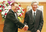 握手を交わす安藤博二会長（左）と安藤剛社長