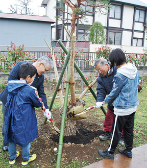 児童と木を植える米山理事長（右）と本多理事