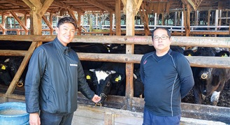 飼育中の相州牛の前で入賞を喜ぶ長崎代表（右）と中川さん