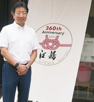 17代当主の賢さんと360周年の記念ロゴの店頭幕