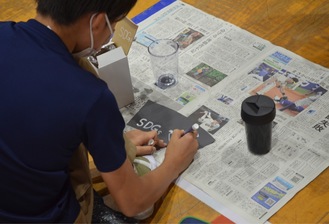 A student reusing wallpaper to make a bottle