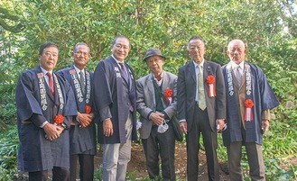 植樹した木の前に並ぶ川口組合長（左から２人目）、守屋市長（同３人目）、松永さん（同４人目）