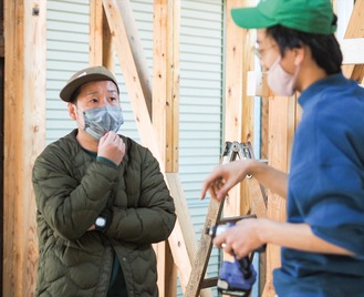 瀬戸米穀店精米工場でアーティストの今西勇太さんと打ち合わせをする平井さん（左）
