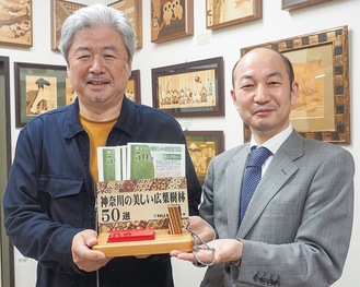 寄木細工のスタンプ台を持つ石川さん（左）と菅原支店長
