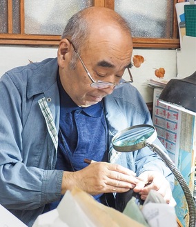手入れをしながら50年間使い続けてきたという印刀で、全身の感覚を使い印章を彫る武井さん