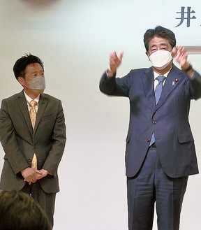 壇上に立つ安倍元首相（右）と井上氏