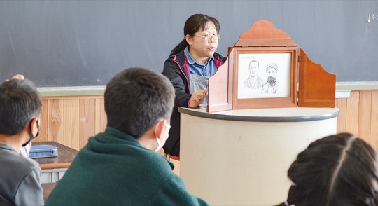 紙芝居を読む北村代表と児童