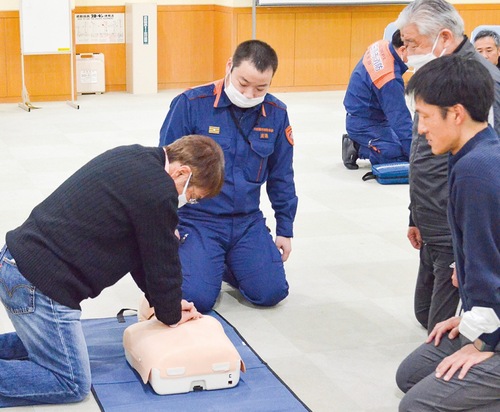 訓練用の人形で講習を受ける参加者