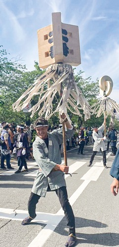 パレードで纏を振る若手の鳶（過去）