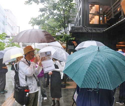 ガイドの説明を聞きながらまちを巡る学生（ミナカ小田原前）