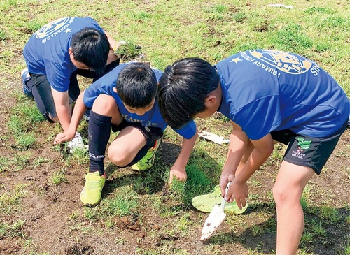 芝生を植えるサッカー少年