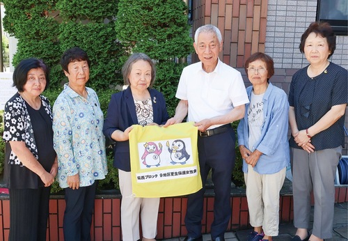 志村理事長に旗を贈る女性会のメンバー