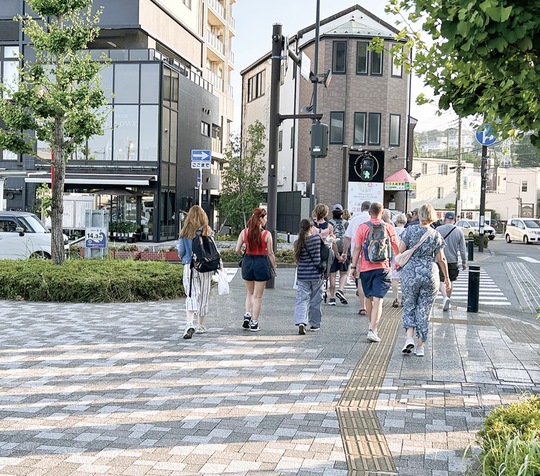 観光バスを降り、ロータリーから小田原駅西口へ向かう外国人観光客