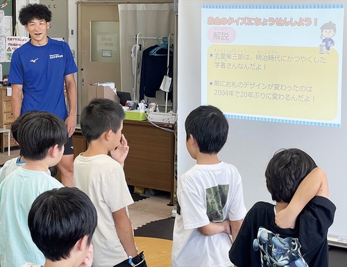 「お金」に関するクイズに挑戦する児童（提供）