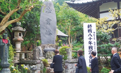 忠霊塔に手を合わせる参列者
