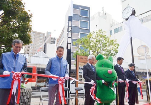 時計塔の前でテープカットを行う須藤会長（左から２人目）ら