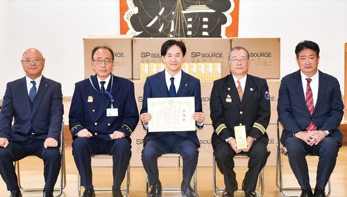 中村消防団長（中央右）から受け取った感謝状を持つ相原社長