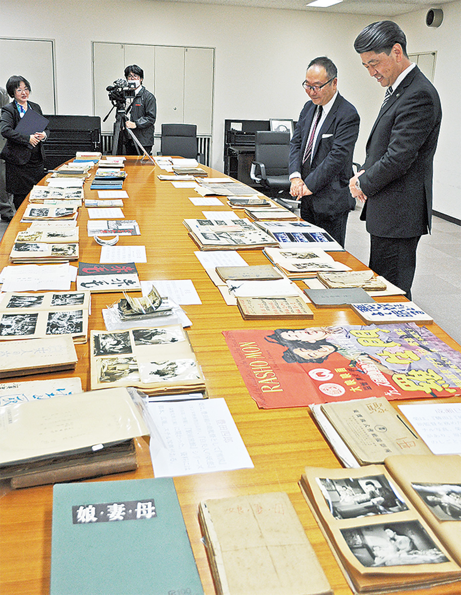 資料を前に榮さんの思い出を語る厚さん(奥)