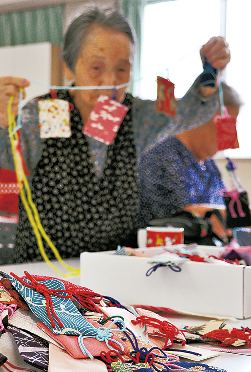 古い着物などの布で作られた短冊を１本の紐につなげるメンバー。中には被災地の人たちの願いや祈りが書かれた紙が入っている