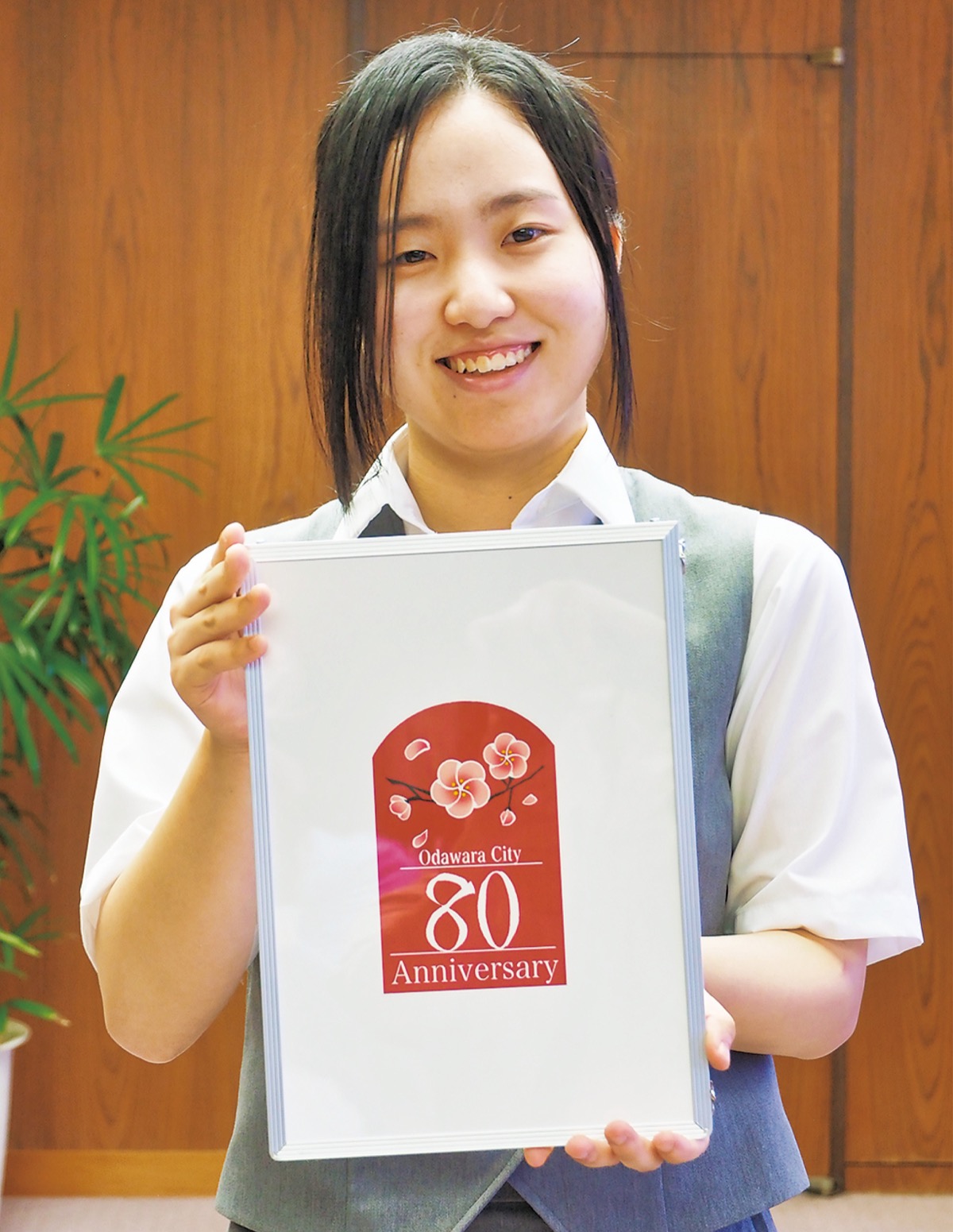 決定したロゴマークを持つ佐野さん