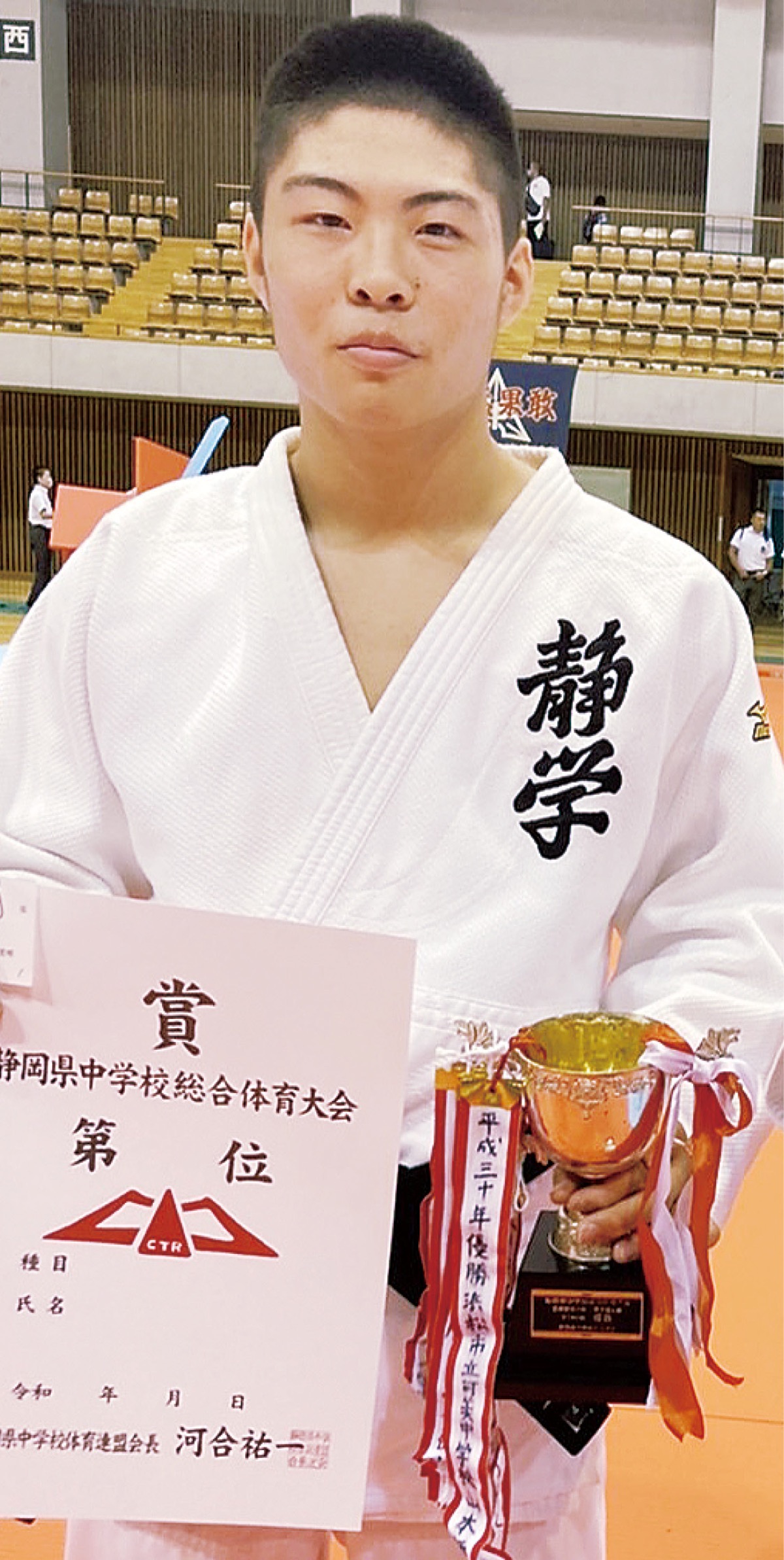 賞状とトロフィーを手にした石井さん