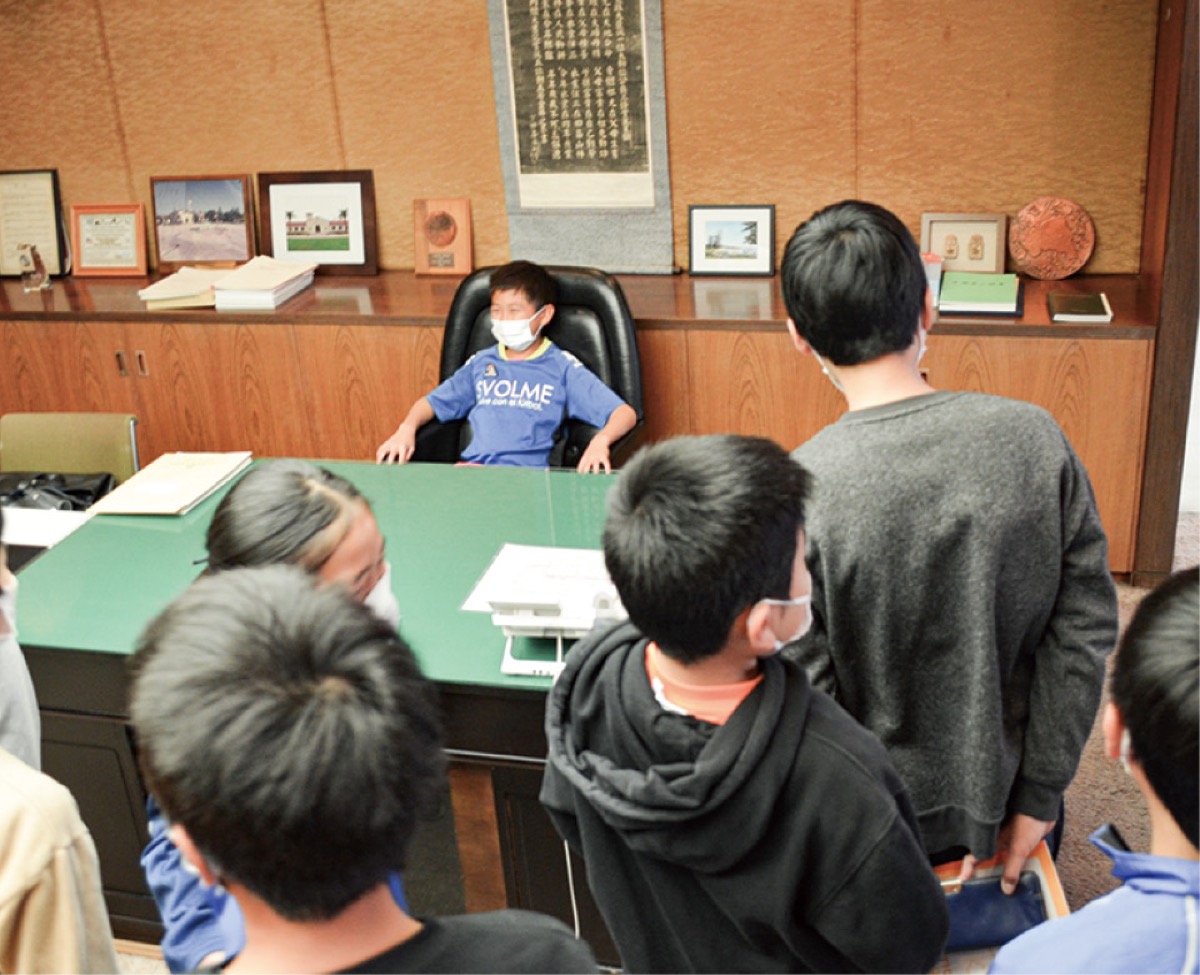 議長室のいすに座る早川小の児童
