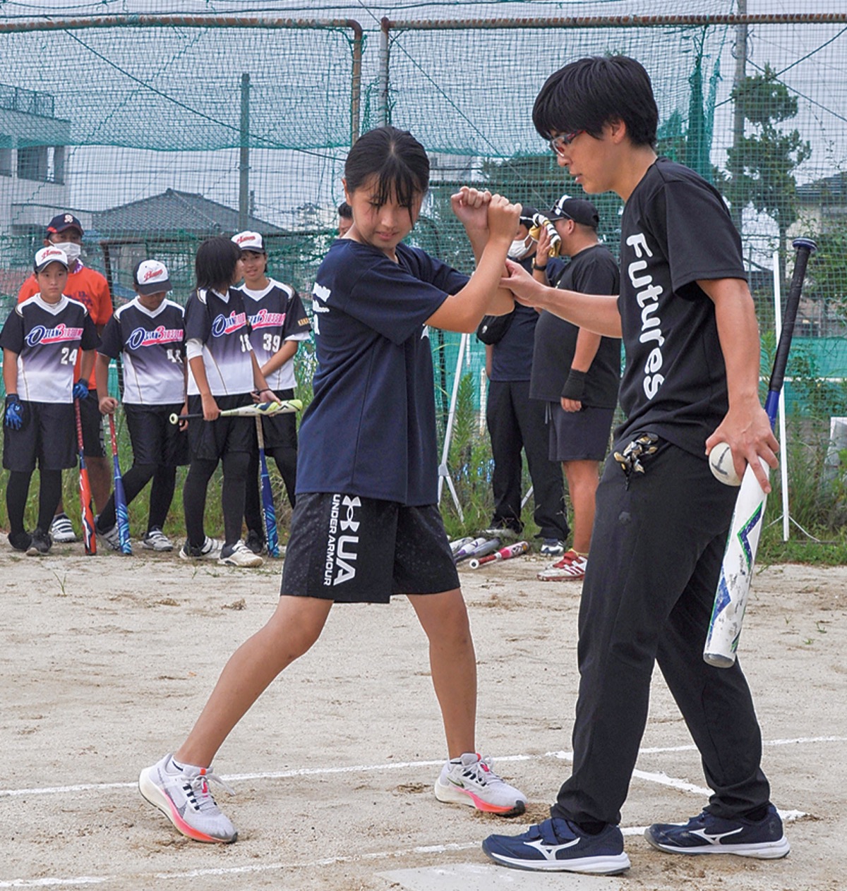 バッティングの指導をする山本さん(右)