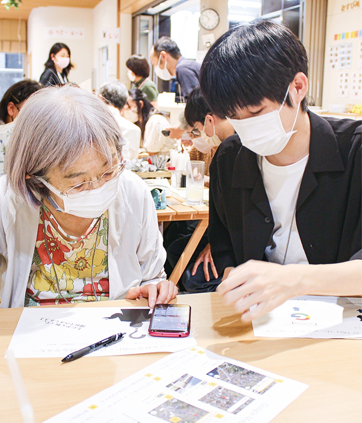 画面操作をしながら指導する高校生(右)