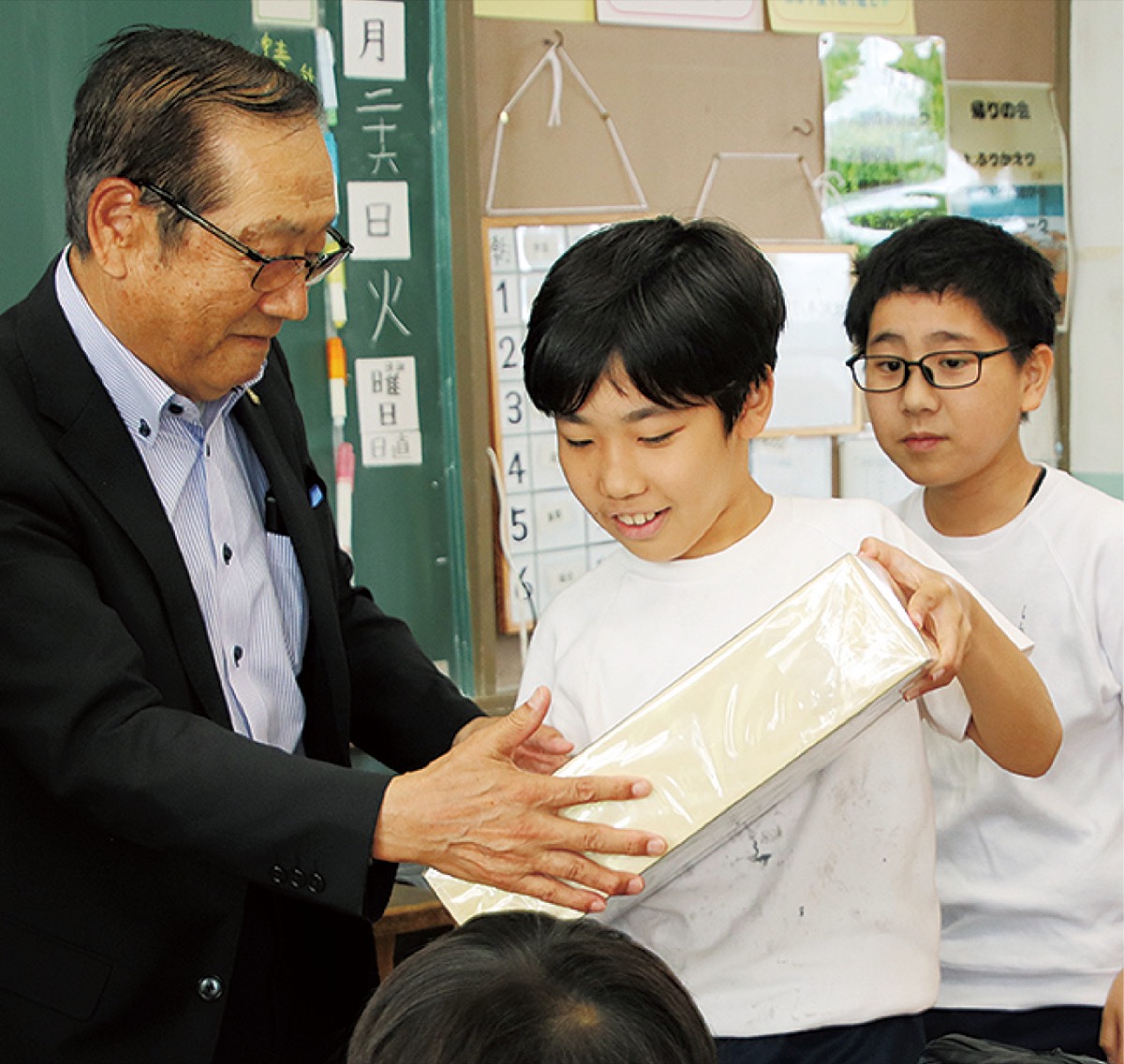 １億円分のレプリカを持ち、重さを実感（左は本多会長）
